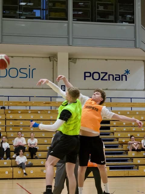 Zawodnicy koszykówki w wyskoku o piłkę w hali sportowej w Poznaniu